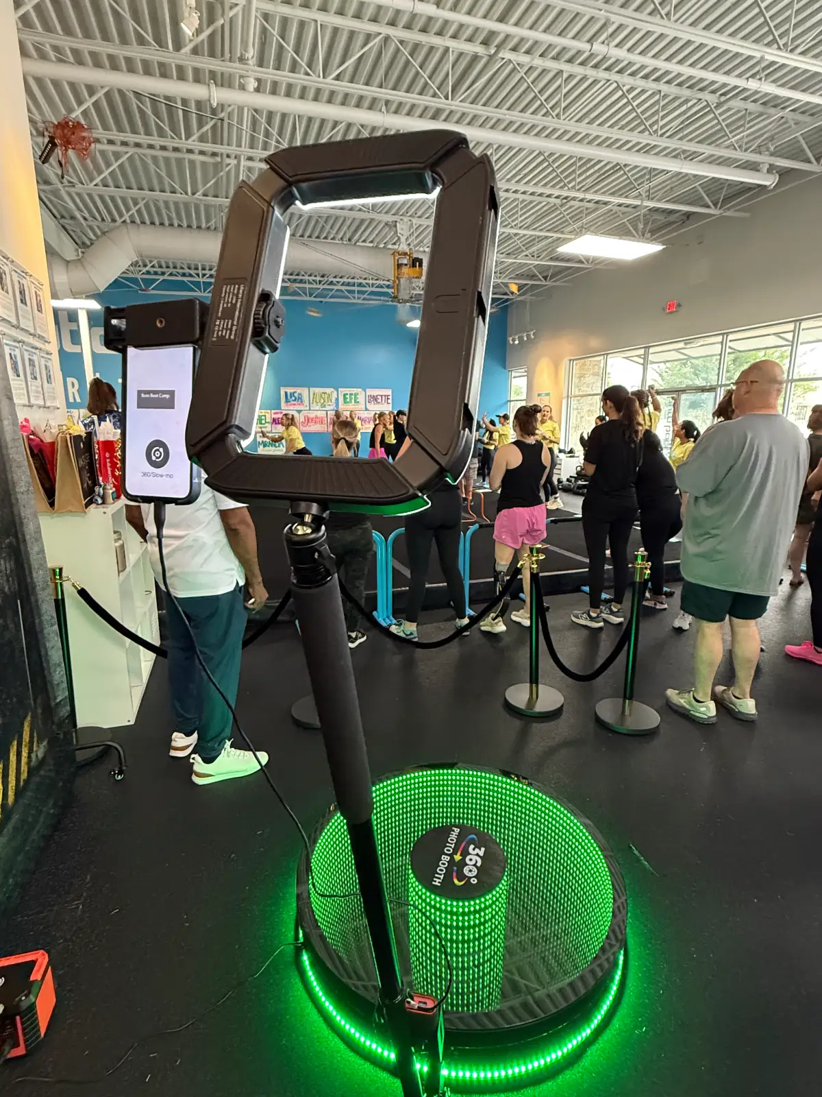 360 photo booth with LED lighting set up at an indoor event venue, ready for guests to capture immersive videos and photos.
