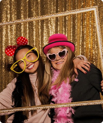 Two women posing with fun accessories.