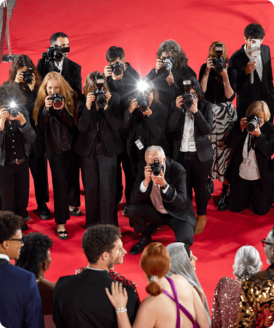 Photographers capturing celebrities on red carpet.